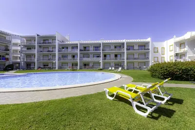 a resort with two chairs and a swimming pool at CORCOVADA SUNSET Just 5 min from the Strip in Albufeira
