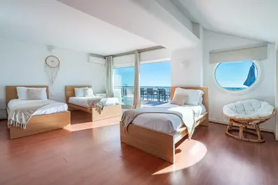 a living room with a staircase and a chair at Luxe Penthouse, BBQ, hot spa, games, ocean view - By Seareen in Albufeira