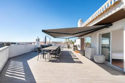 a kitchen and living room with a table in a room at Luxe Penthouse, BBQ, hot spa, games, ocean view - By Seareen in Albufeira