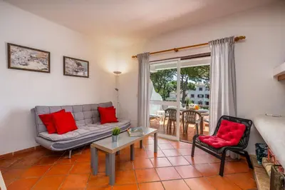 a living room with a couch and a table and chairs at Pool Apartment Vilamoura near Old Village in Quarteira
