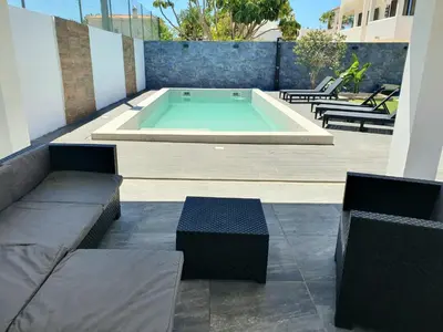 a swimming pool with two chairs and a bench at Fernando Pessoa Villa in Faro