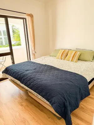 a bed with a blue comforter in a room at Fernando Pessoa Villa in Faro
