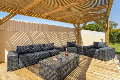 a patio with a couch and a table on a wooden deck at Villa Castelo by Algarve Holidays in Albufeira