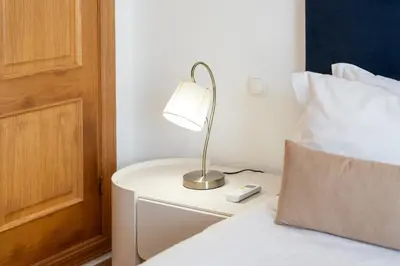 a lamp on a night stand next to a bed at Villa Castelo by Algarve Holidays in Albufeira