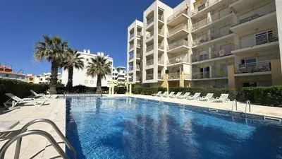 a swimming pool in front of a large apartment building at Wave by Check-in Portugal in Albufeira