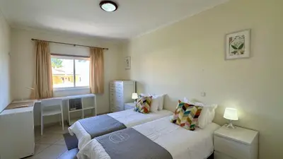 a bedroom with two beds and a desk and a window at Wave by Check-in Portugal in Albufeira