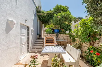 a patio with a table and benches in front of a building at Casa Aurora in Vale do Lobo