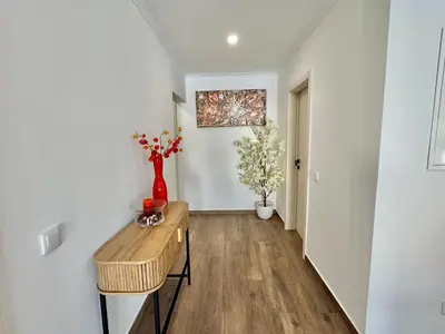 a hallway with a table and a vase of flowers at Villa 20age - Jacuzzi - Heated pool - Algarve in Albufeira