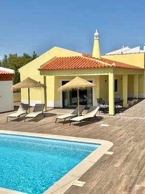 a resort with a pool and chairs and umbrellas at Villa 20age - Jacuzzi - Heated pool - Algarve in Albufeira