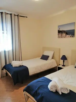 a hotel room with two beds and a window at Casinha da Galé in Galé