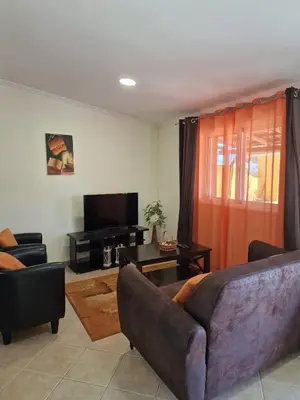 a living room with a couch and a television at Casinha da Galé in Galé
