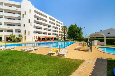 a hotel with a swimming pool and a building at Alamos - Dream Lodging in Albufeira