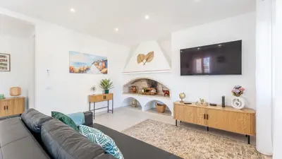 a living room with a couch and a fireplace at Vivenda Neves in Albufeira by LovelyStay in Vale de Pedras