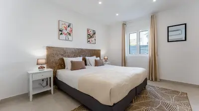a white bedroom with a large bed and a window at Vivenda Neves in Albufeira by LovelyStay in Vale de Pedras