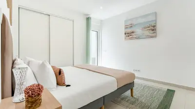 a white bedroom with a bed and a window at Vivenda Neves in Albufeira by LovelyStay in Vale de Pedras