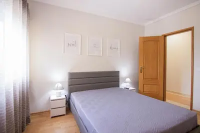 a bedroom with a bed and two lights on the wall at Modern 3-bedroom Retreat in Faro's City Center in Faro