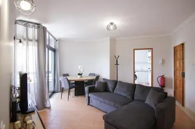 a living room with a couch and a table at Modern 3-bedroom Retreat in Faro's City Center in Faro