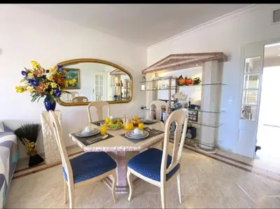 a dining room with a table and chairs and a mirror at Vilamoura Central in Quarteira