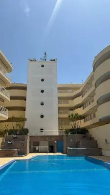 a building with a swimming pool in front of a building at Vilamoura Central in Quarteira