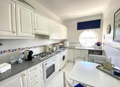 a kitchen with white cabinets and a stove top oven at Vilamoura Central in Quarteira