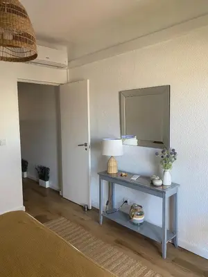 a living room and kitchen with a table and a mirror at LizHolidays in Albufeira