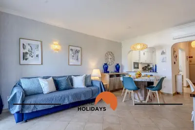 a living room with a blue couch and a kitchen at #322 Albufeira Family Stay by Home Holidays in Albufeira
