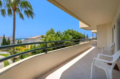 a balcony with two chairs and a palm tree at Apartment Galé Mar By Zimzala & Bedzy in Guia