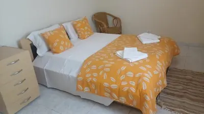 a bedroom with a bed with an orange blanket at Casa Gomez C in Albufeira