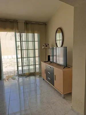a living room with a tv and a mirror at Casa Gomez C in Albufeira