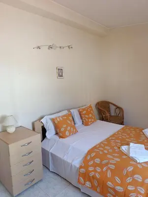 a bedroom with a bed and a dresser with an orange blanket at Casa Gomez C in Albufeira