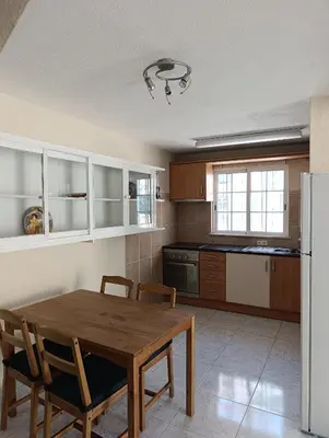 a kitchen with a table and chairs and a refrigerator at Casa Gomez C in Albufeira