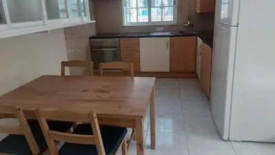 a kitchen with a wooden table and a refrigerator at Casa Gomez C in Albufeira