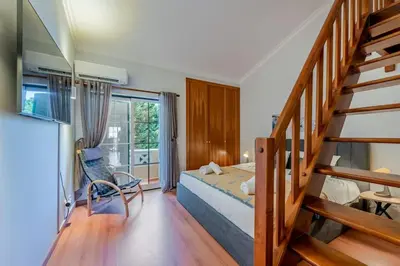 a bedroom with a bed and a staircase in a room at Sao Rafael TownHouse with Pool in Albufeira