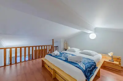a bedroom with a bed with a blue and white blanket at Sao Rafael TownHouse with Pool in Albufeira