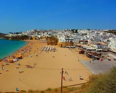 a group of people on a beach with buildings at Villa David in Albufeira