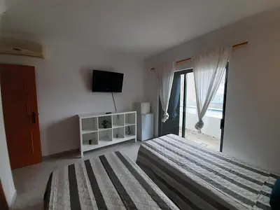 a bedroom with a bed and a tv and a window at Villa David in Albufeira