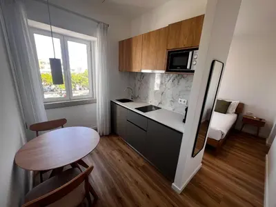 a white room with a tv on a wall at Carmo Suites in Faro