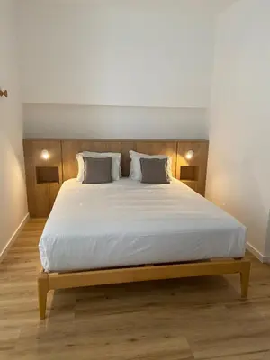 a bedroom with a bed and a desk with a mirror at Carmo Suites in Faro