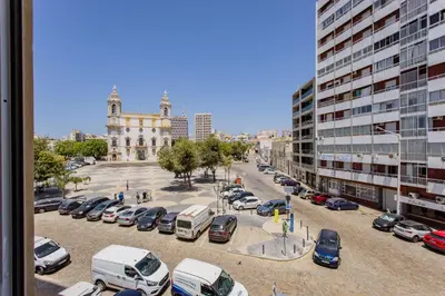 a parking lot with cars parked in front of a building at Carmo Suites in Faro
