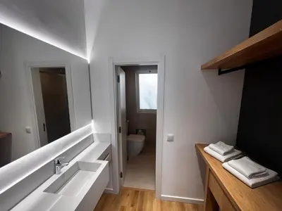 a white bathroom with a sink and a toilet at Carmo Suites in Faro