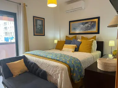 a bedroom with a bed and a chair at Apartamento Dubai By Garvetur in Quarteira