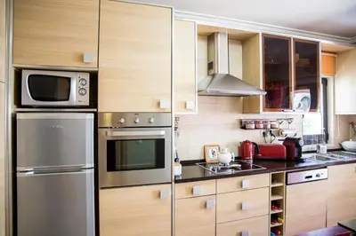 a kitchen with stainless steel appliances and wooden cabinets at Apartamento Dubai By Garvetur in Quarteira