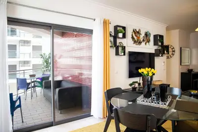 a dining room with a table and a sliding glass door at Apartamento Dubai By Garvetur in Quarteira