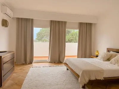 a bedroom with a bed and a large window at Casa Vaga - Garrão beach House