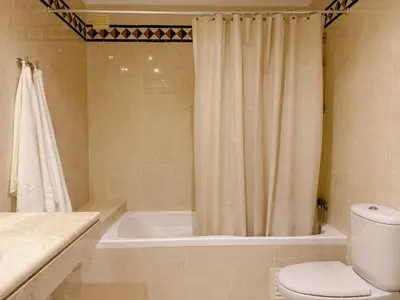 a bathroom with a shower curtain and a toilet at Casa Vaga - Garrão beach House