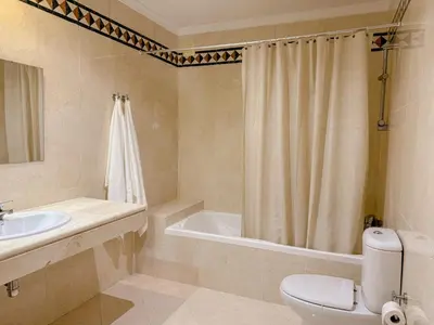 a bathroom with a tub and a toilet and a sink at Casa Vaga - Garrão beach House