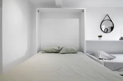 a white bedroom with a bed and a mirror at Mi Casa Es Su Casa Nº1 in Albufeira