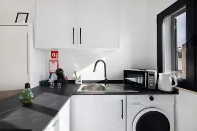 a white kitchen with a sink and a microwave at Mi Casa Es Su Casa Nº3 in Albufeira