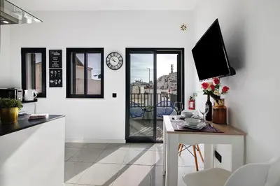 a kitchen with a table and a clock on the wall at Mi Casa Es Su Casa Nº3 in Albufeira