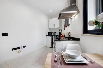 a kitchen with a table with a wine glass at Mi Casa Es Su Casa Nº2 in Albufeira
